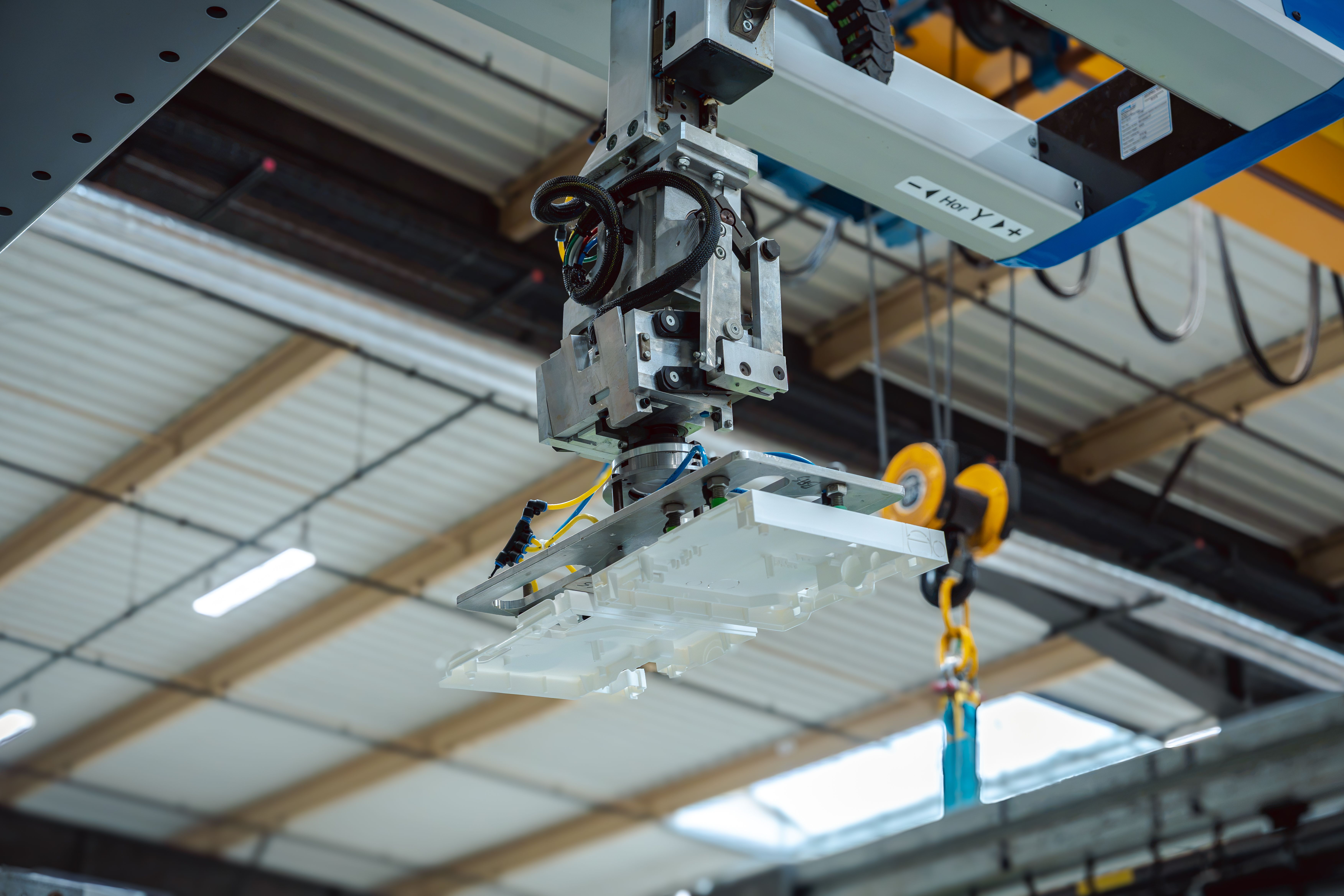 Pièce d’un coffret en cours de fabrication, porté par un bras robotisé