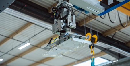 Pièce d’un coffret en cours de fabrication, porté par un bras robotisé
