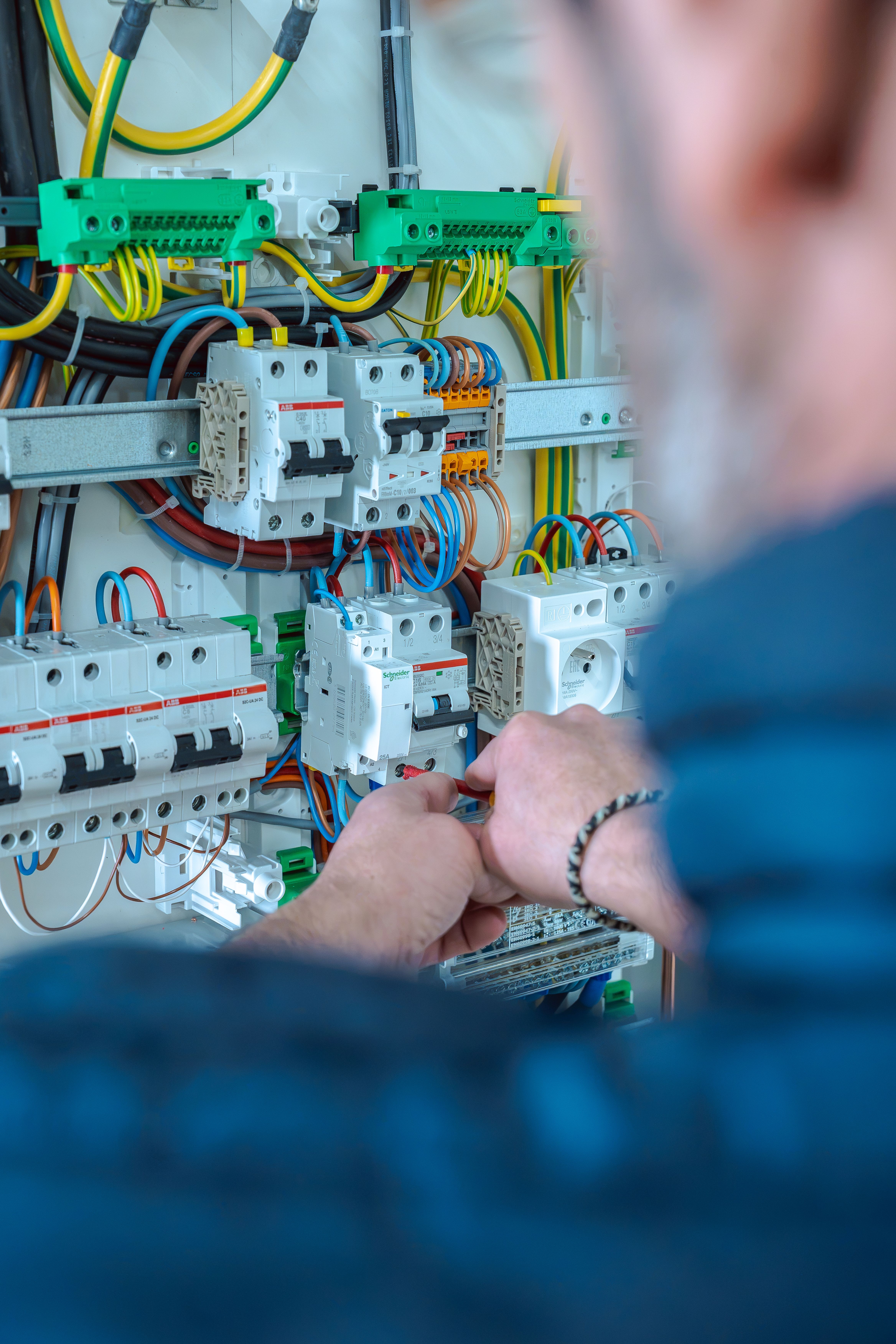 Mains d'un homme travaillant sur l'intérieur d'un coffret électrique