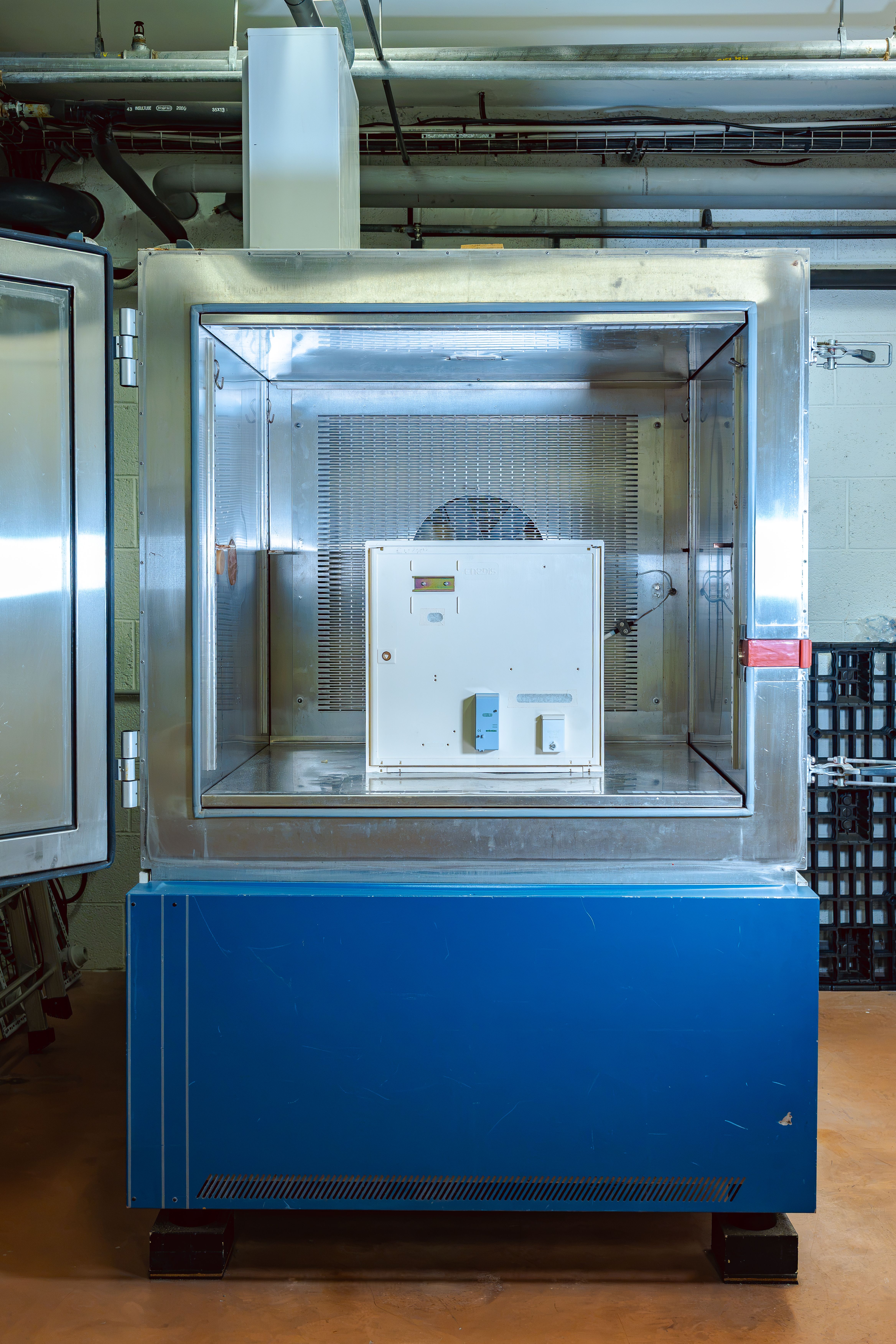 Coffret électrique à l’intérieur d’une chambre climatique porte ouverte, avant un test 