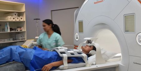 Femme sur une plateforme IRM avec une médecin à côté