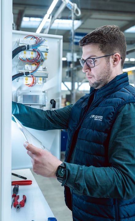 Homme travaillant sur un shelter avec un document dans la main