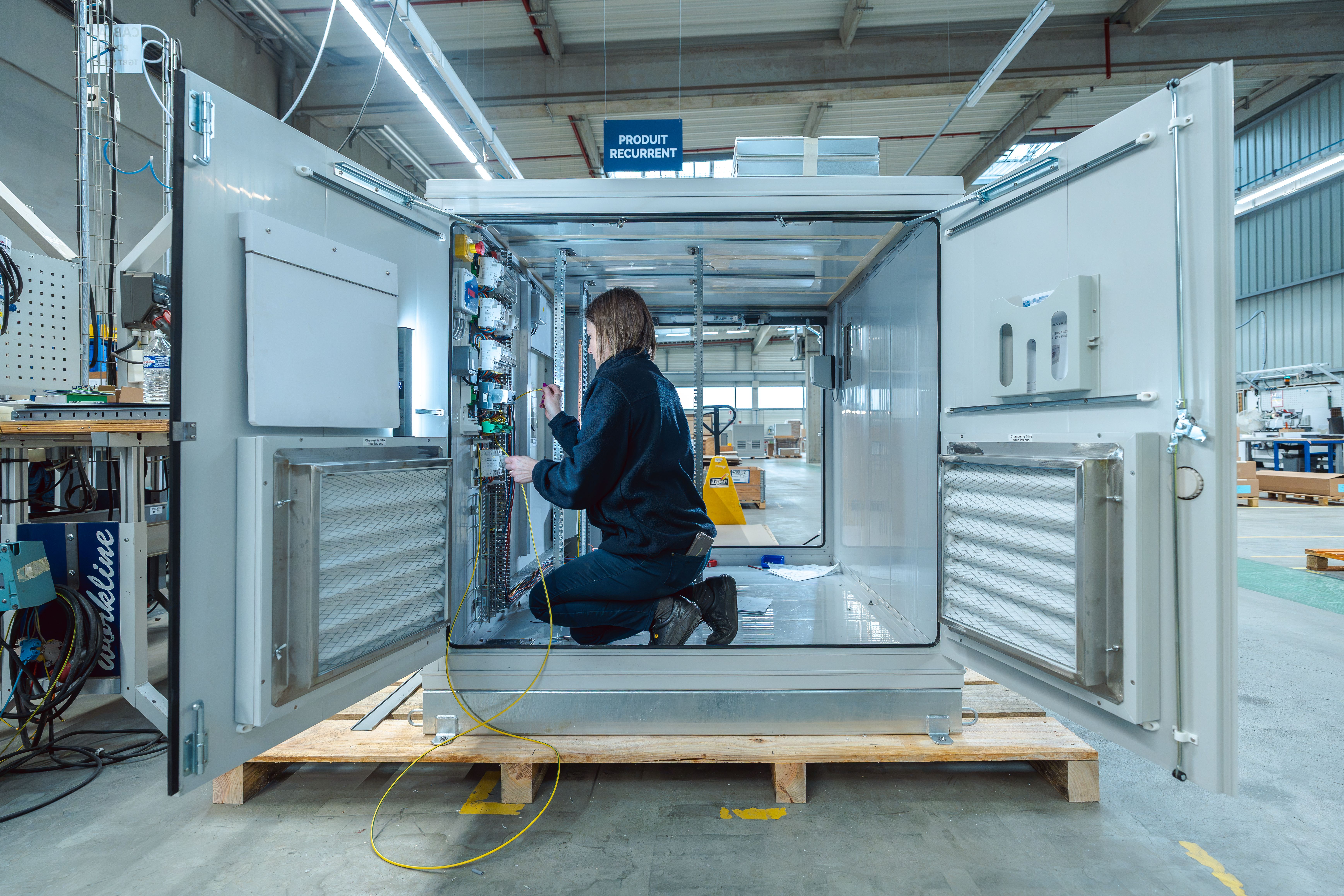 Technicienne en train de câbler l’intérieur d’une armoire électrique