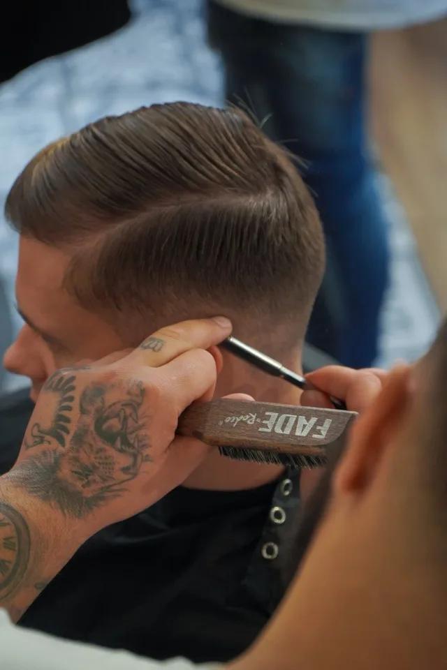 Finishing a fade with a brush at Men's Cave Barbers