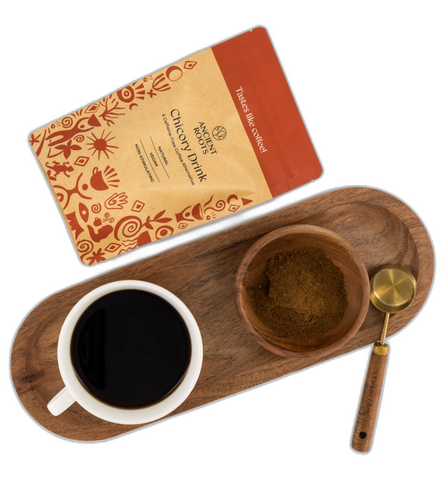 Top view of a pack of Ancient Roots Chicory Drink beside a freshly prepared cup of chicory on a serving tray.