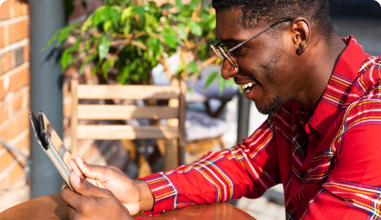 Man smiling while using smartphone outdoors