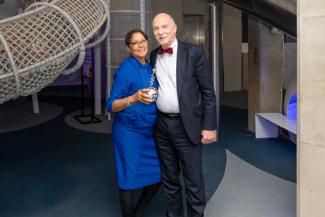 Two people posing in front of the National Children's Museum Dream Machine