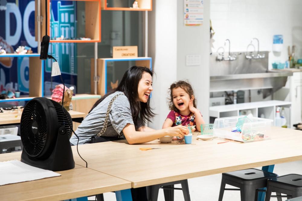 Mother and daughter laugh together while tinkering in the Tinkerers Studio.