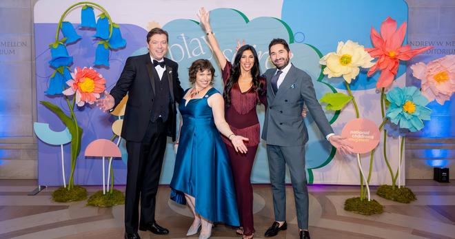 National Children's Museum President and CEO, Kiryn Hoffman, with event co-chairs John Drew, Sepe Zuccari, and Jason Zuccari, posing in front of the event photo backdrop