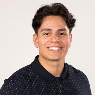 Headshot of Cesar Alcantara wearing a black shirt with white polk a dots