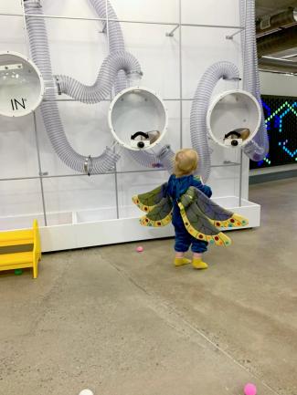several rolling contraptions resting in a green hula hoop surrounded by white ramps.