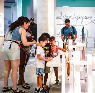 A family engaging with the Art + Tech exhibit