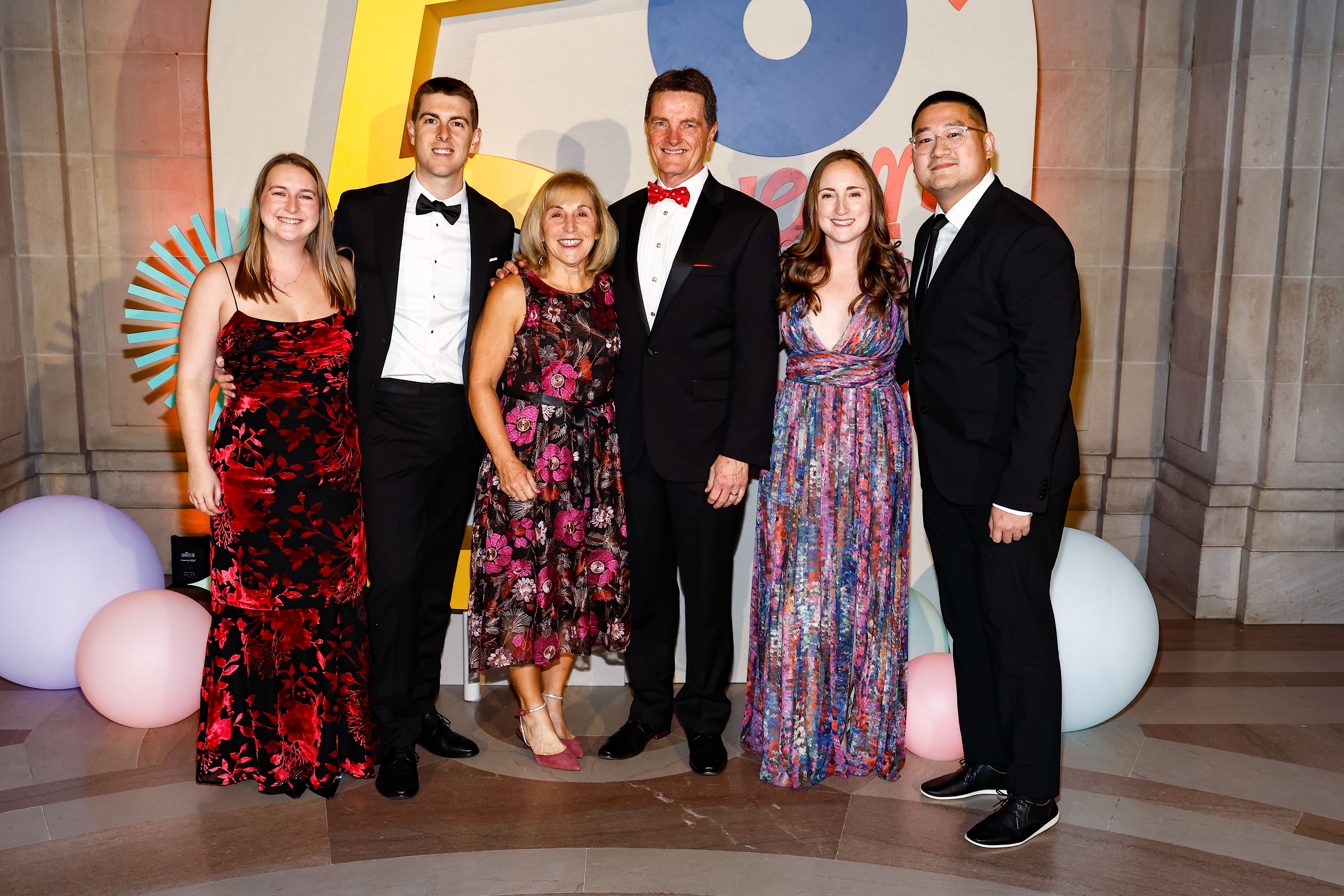 People posing in front of the National Children's Museum Dreamers Gala step and repeat. 
