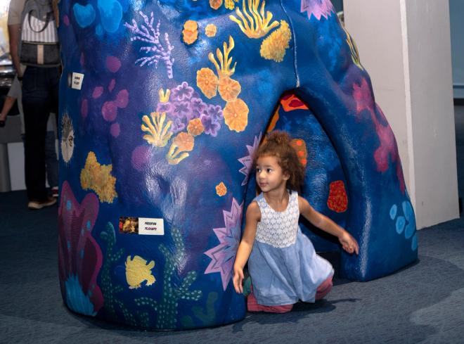 Little girl peeking out of an underwater landscape