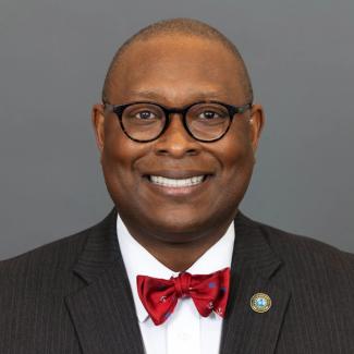 Headshot of Dr. Moore on a gray background