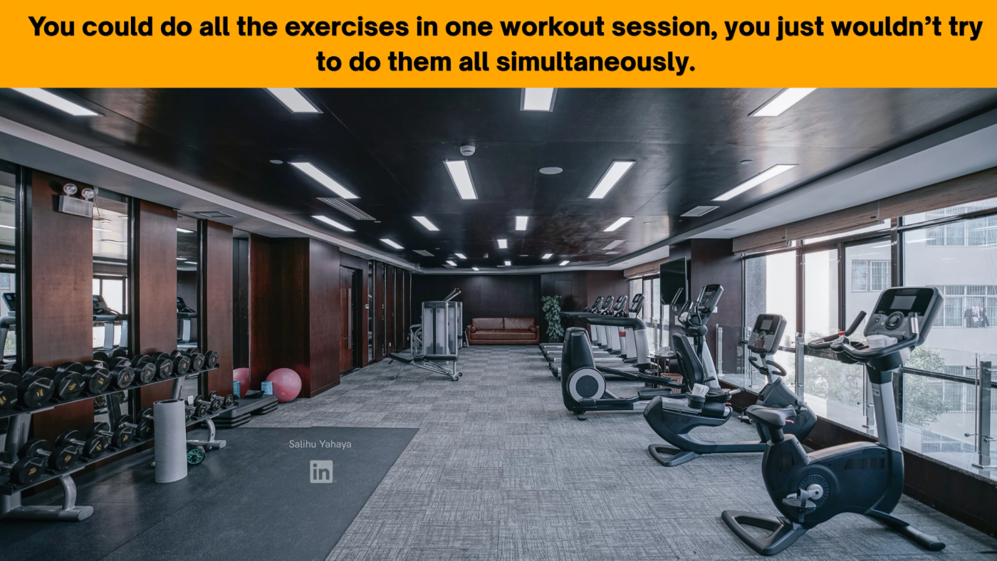 An empty indoor gym with racks of dumbbells, exercise balls and a weight bench on one side and a row of treadmills, bikes and cross-trainers along the windows on the other. Caption: "You could do all the exercises in one workout session; you just wouldn't try to do them all simultaneously."