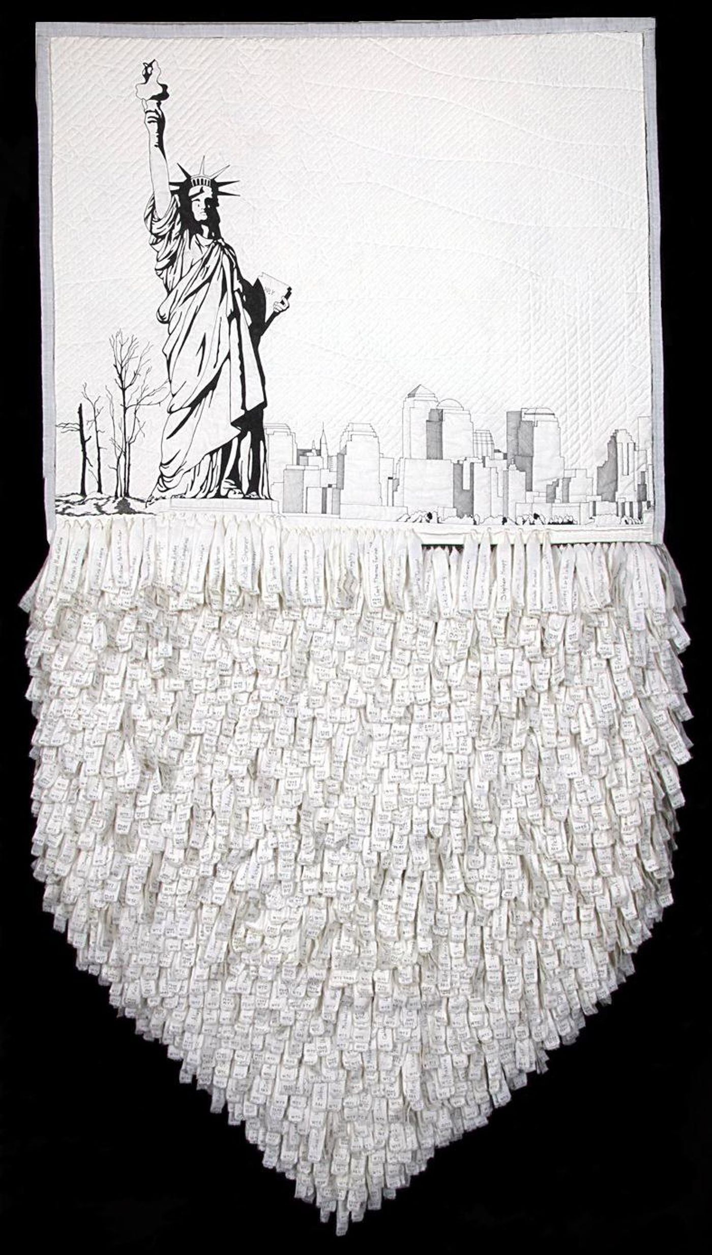 Memorial quilt of the Statue of Liberty and lower Manhattan skyline in black on white, with hundreds of hand-lettered fabric name strips hanging below.