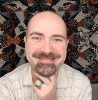 Michael Eason smiles with his chin in his hand.