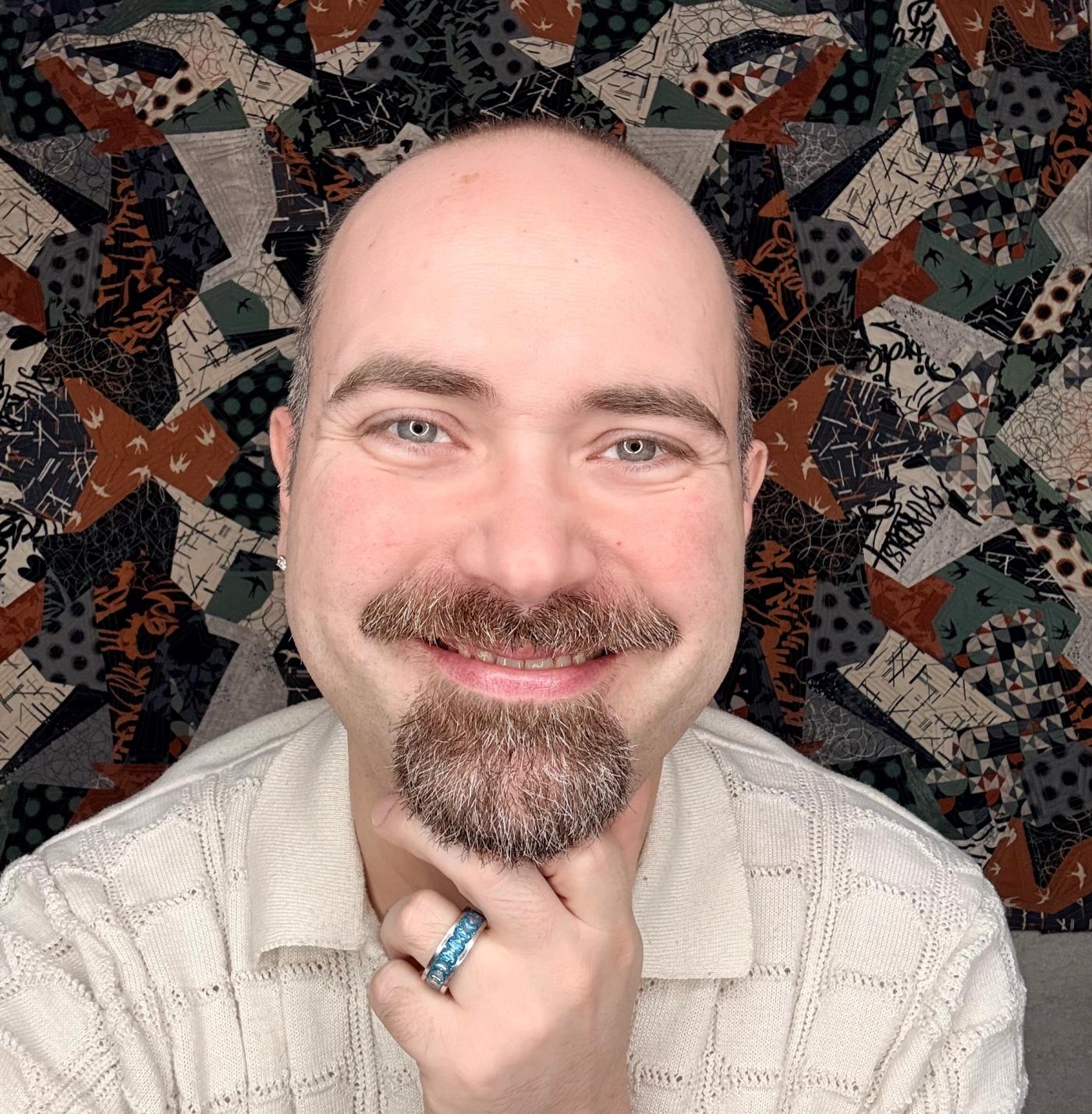 Michael Eason smiles with his chin in his hand.