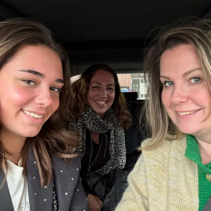 Selfie van drie lachende collega’s in de auto