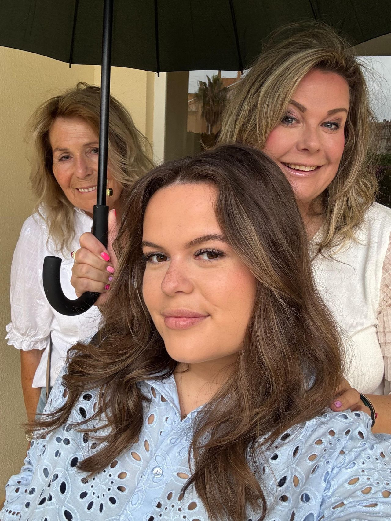 Selfie van drie vrouwen onder een paraplu in de zon