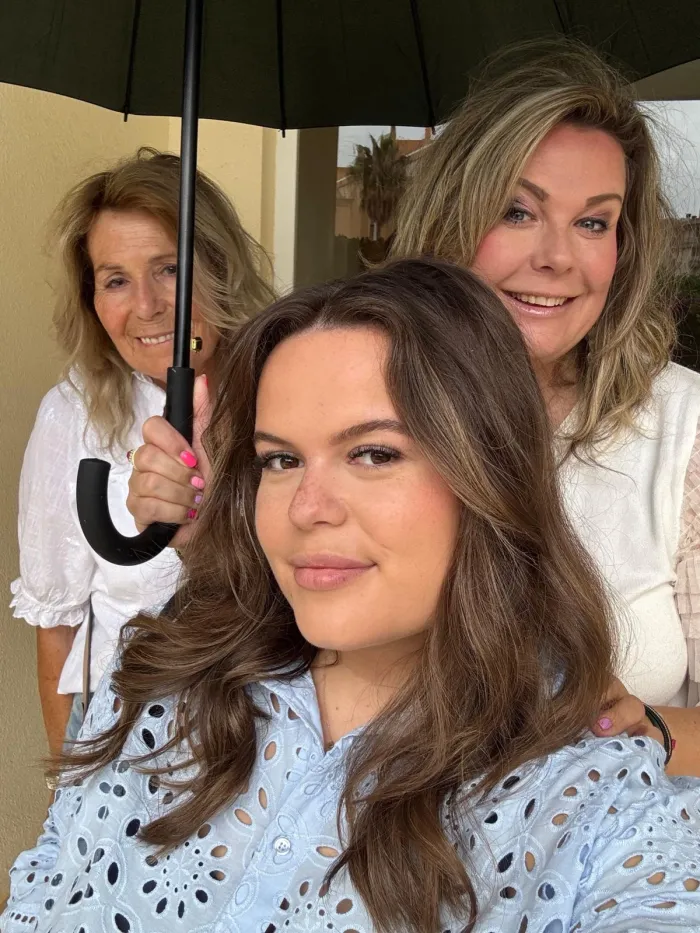 Selfie van drie vrouwen onder een paraplu in de zon