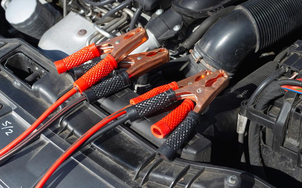Starthilfekabel im offenen Motorraum eines Autos