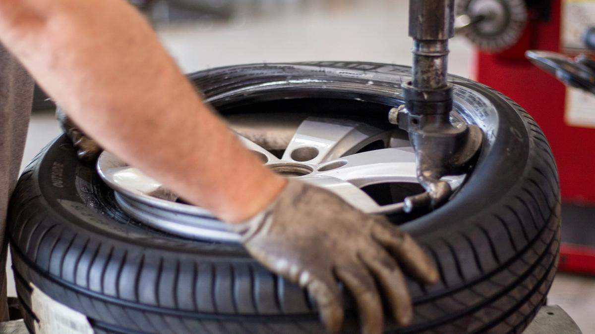A mechanic fitting a tyre on the tyre-changing machine at the garage