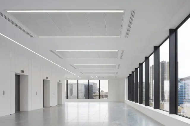 A glass double height entrance with circular drum doors
