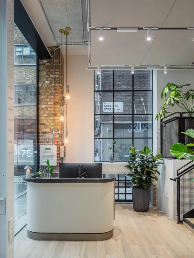 An oval reception desk in a converted warehouse office