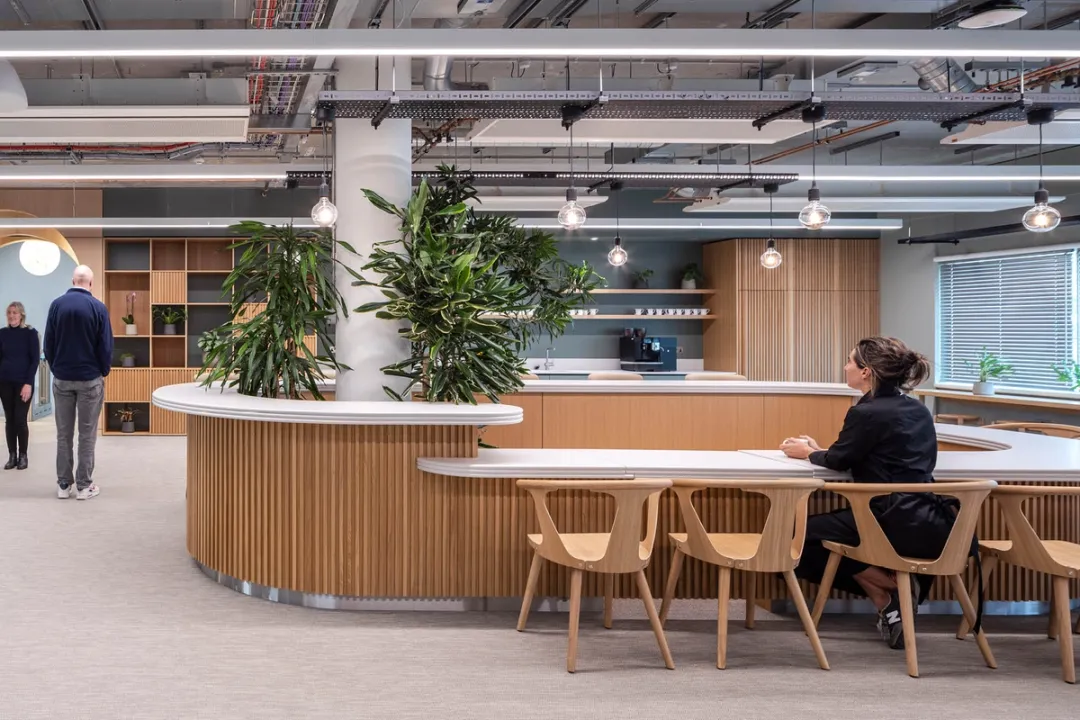 Large circular wooden bar desk surrounded by chairs