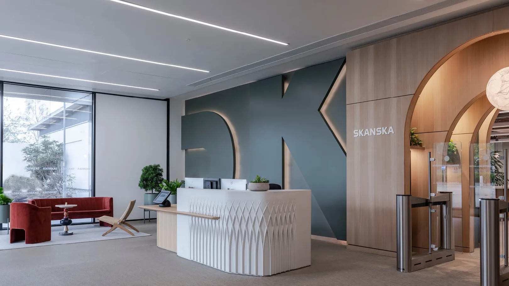 A reception desk, red lobby seating and speed gates