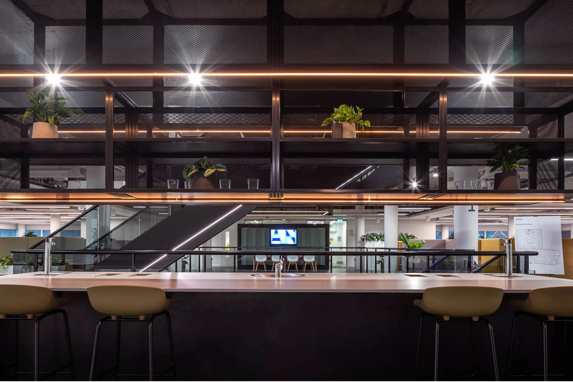 A sleek kitchenette bar with high stools and a central sink