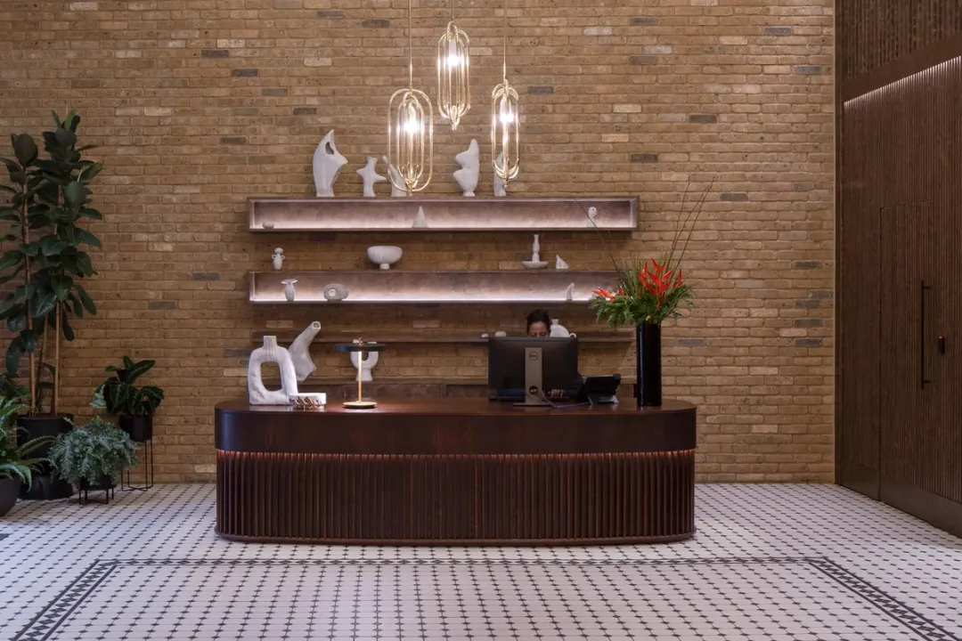 A brown reception desk with accessories and plants 
