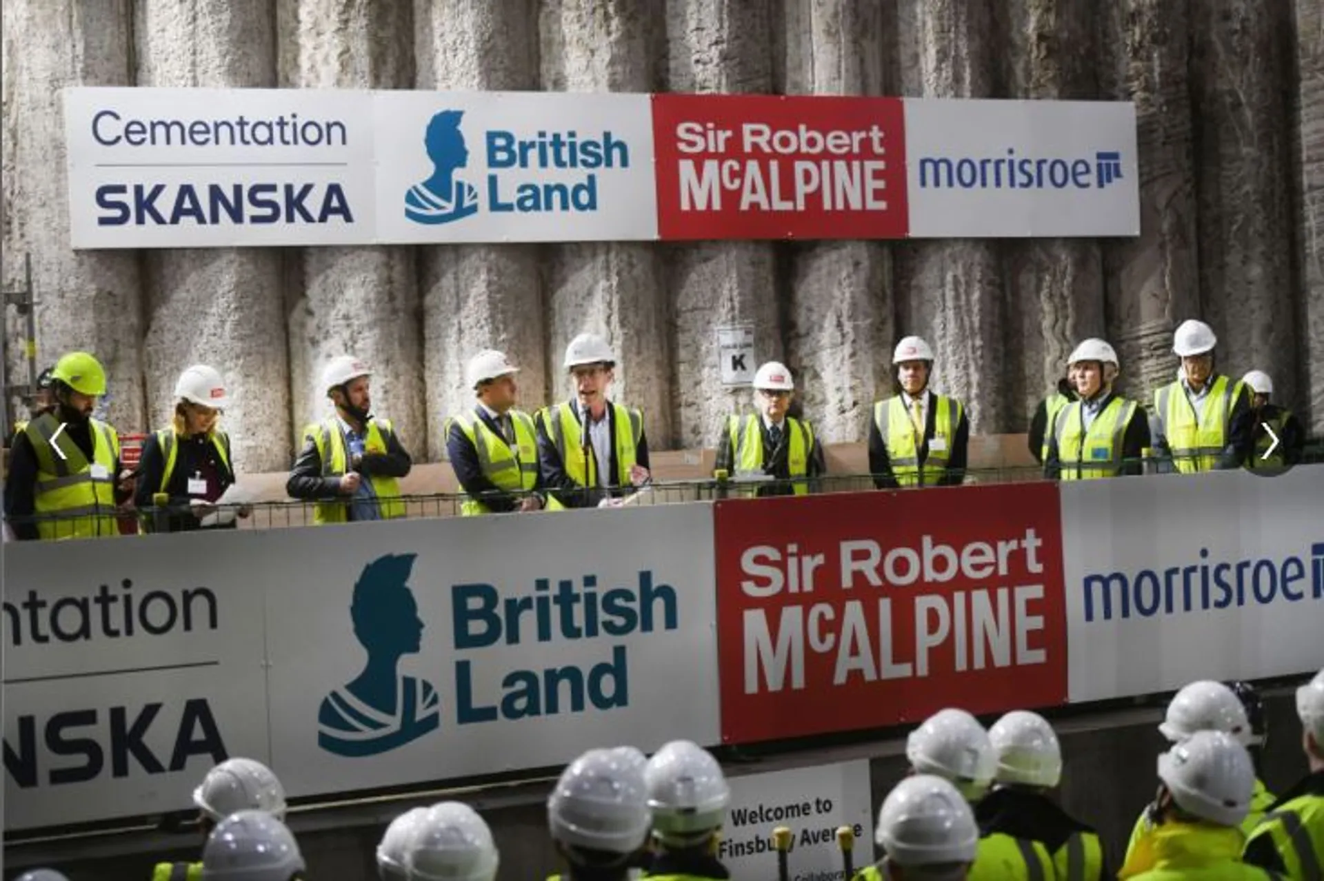People giving a speech onsite at underconstruction building
