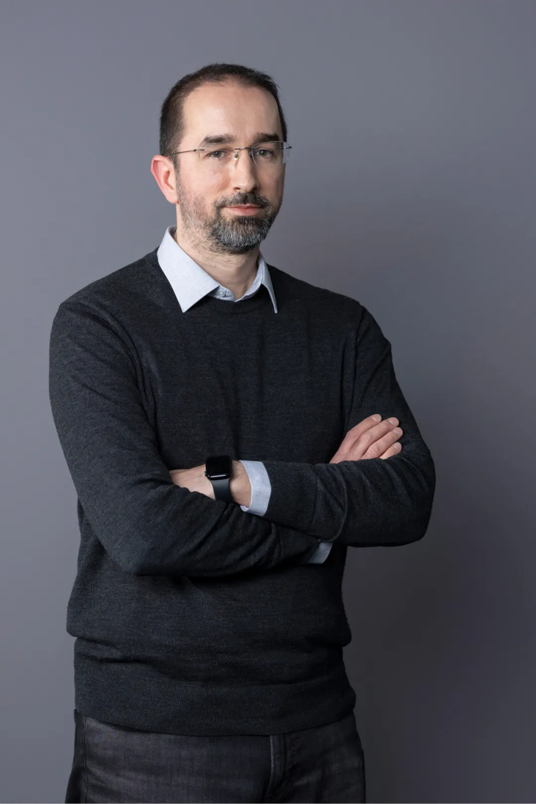 Portrait of person in white shirt and grey sweater