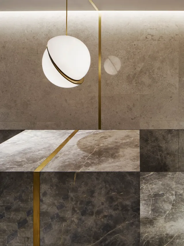 Close up of grey marble reception desk with glowing orb pendant light above