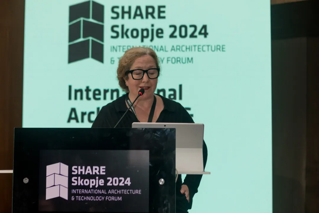 Etain talking on a presentation podium