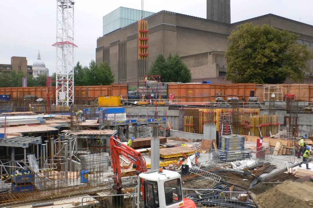 Construction site with cranes, diggers and steel rods, Tate Modern building in background