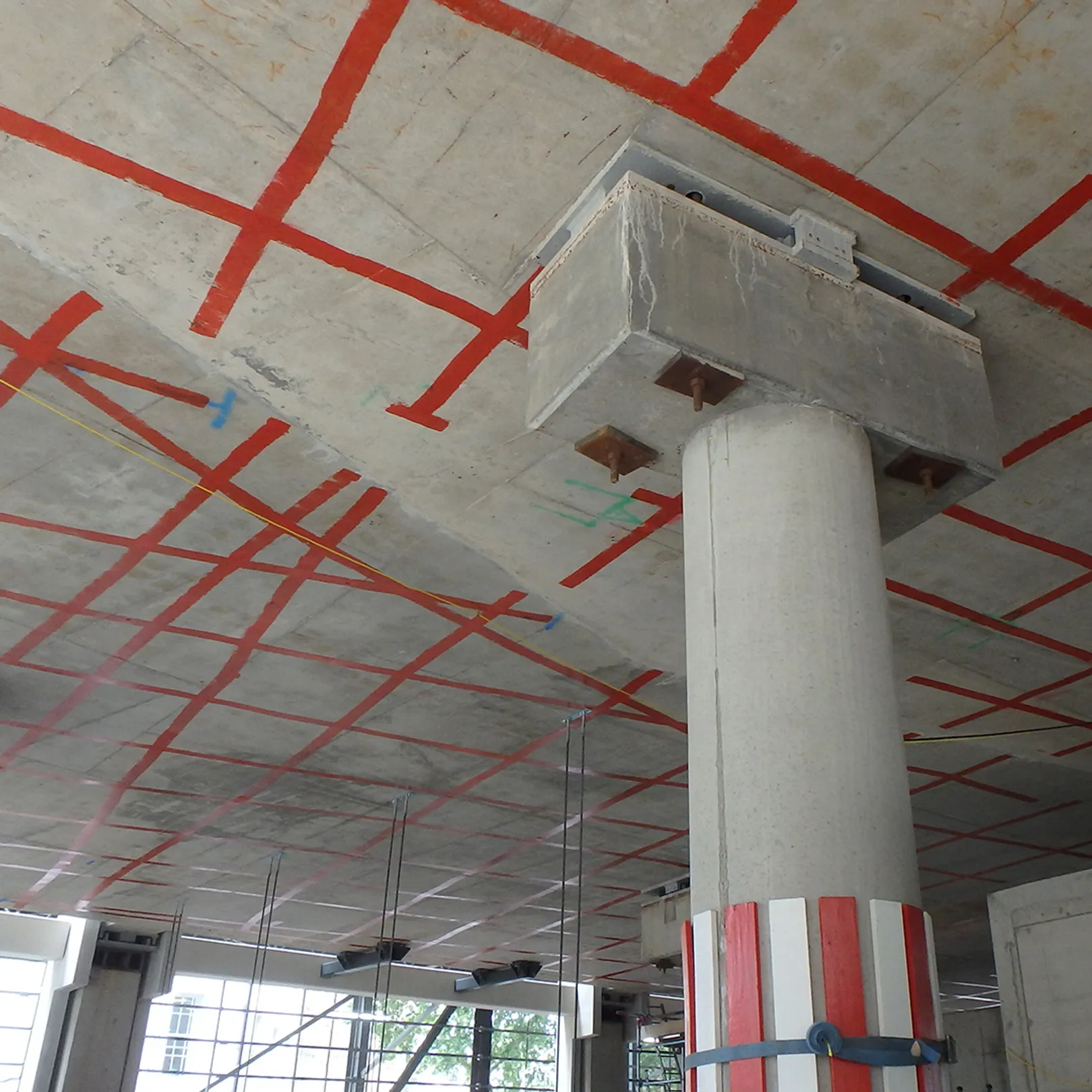 Concrete ceiling and pillar marked with grid of red tape