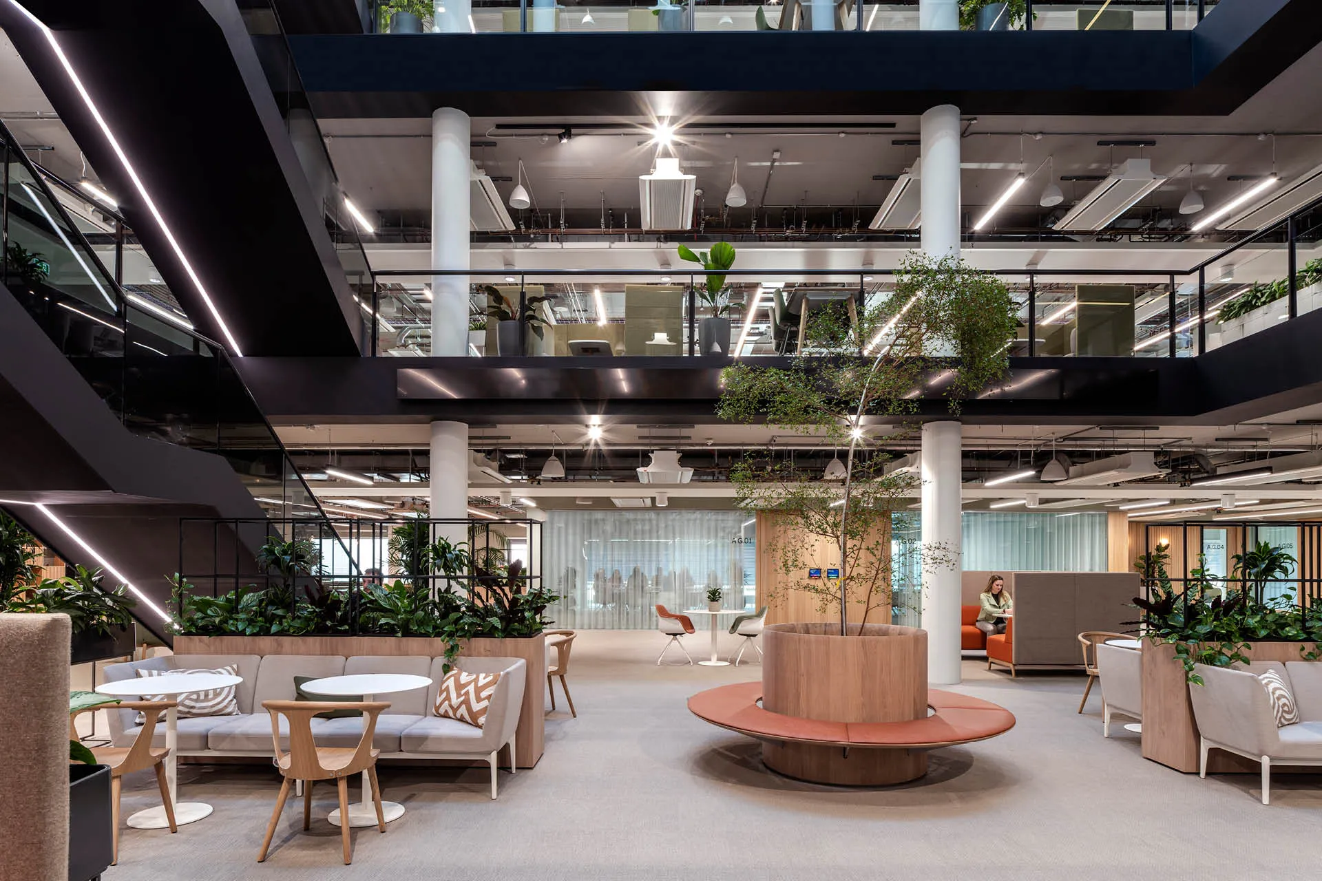 A view of the central atrium with a tree, tables and chairs at the base