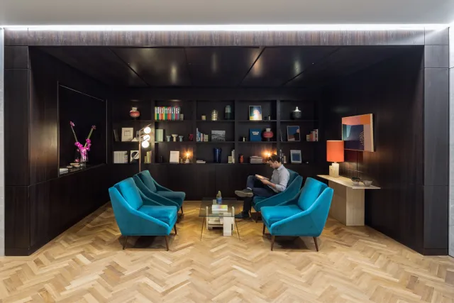 members lounge with wooden floor and turquoise sofas