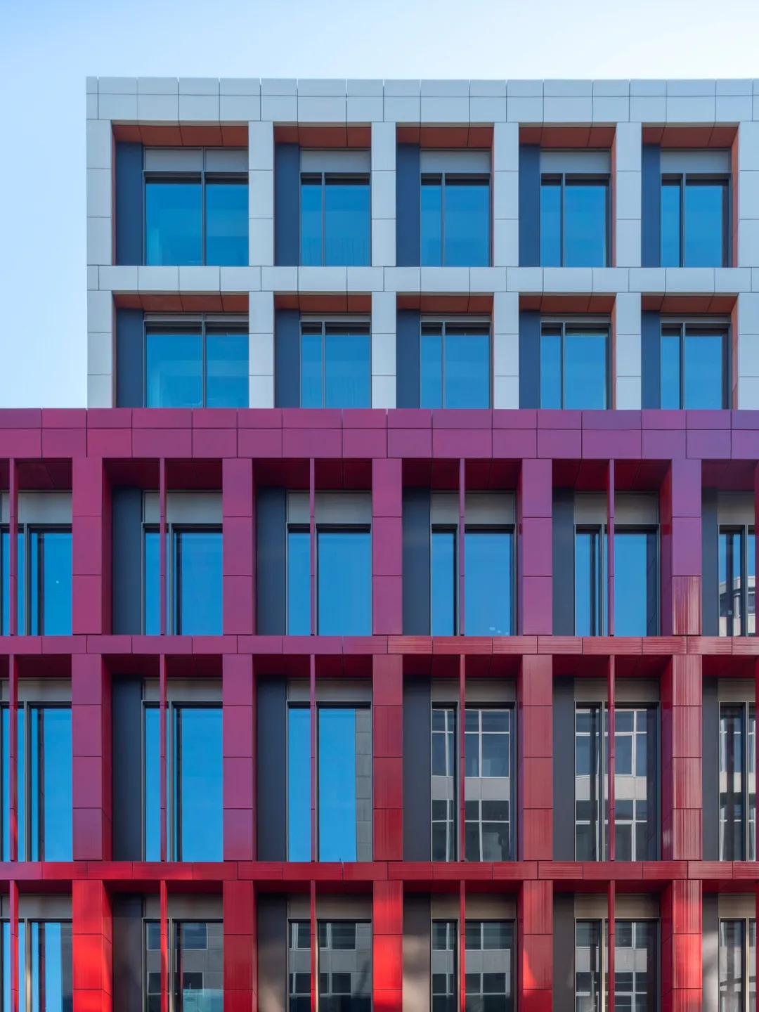 Close up of building facade with red and white and windows