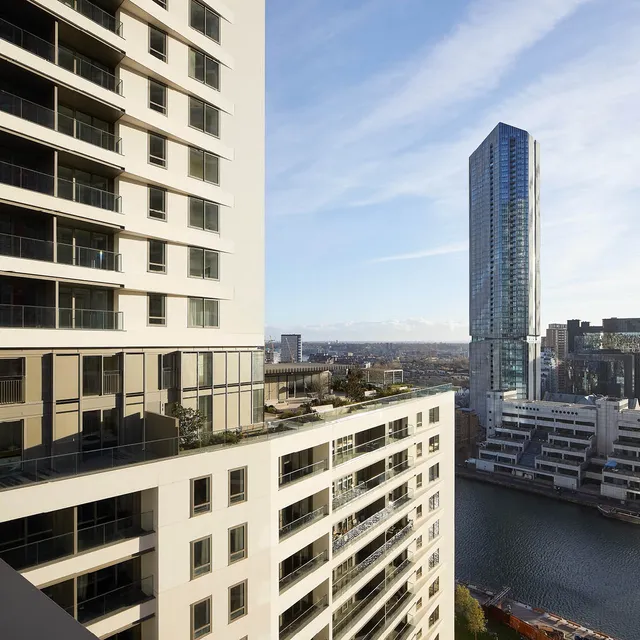 A tall white building's facade and roof terrace