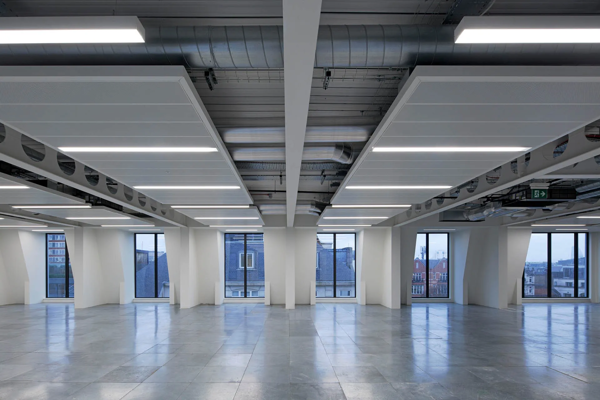 A dusk image of a CAT A floor looking toward full height windows with a semi-exposed ceiling