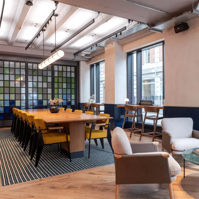 Long meeting table with yellow chairs and feature lighting