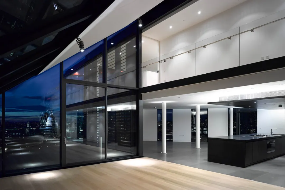 A large open plan kitchen with mezzanine above and glass wall overlooking London's South Bank