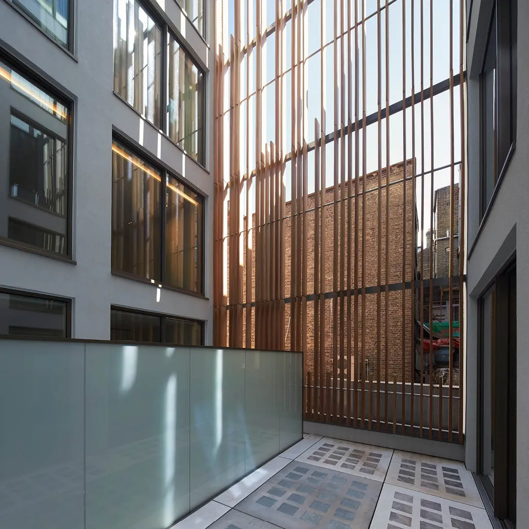 Courtyard with glass block floor, frosted central screen, white buildings with large windows 