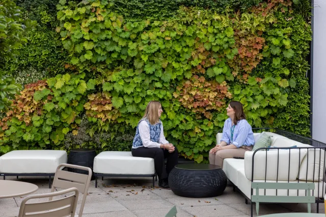 Two people sitting in front of a green wall