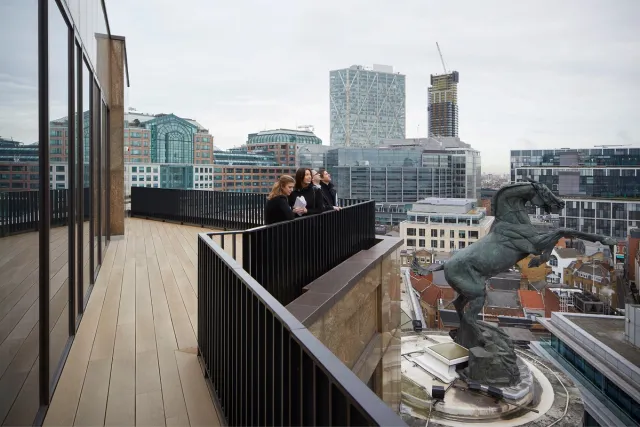 People stand on a terrace overlooking the City of London